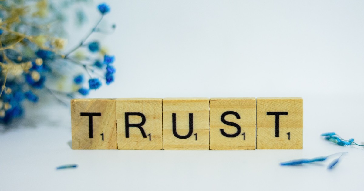 The word ’trust’ spelled out in Scrabble letters (Source: Unsplash/faithgiant)